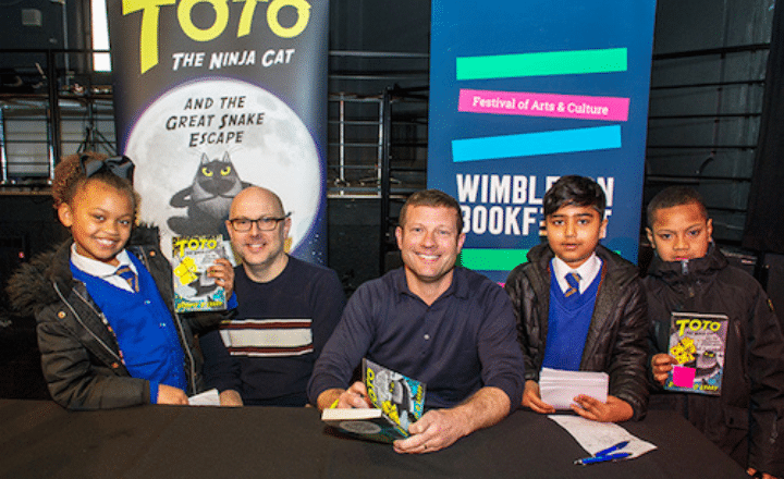 Dermot O'Leary with young fans holding the book Toto