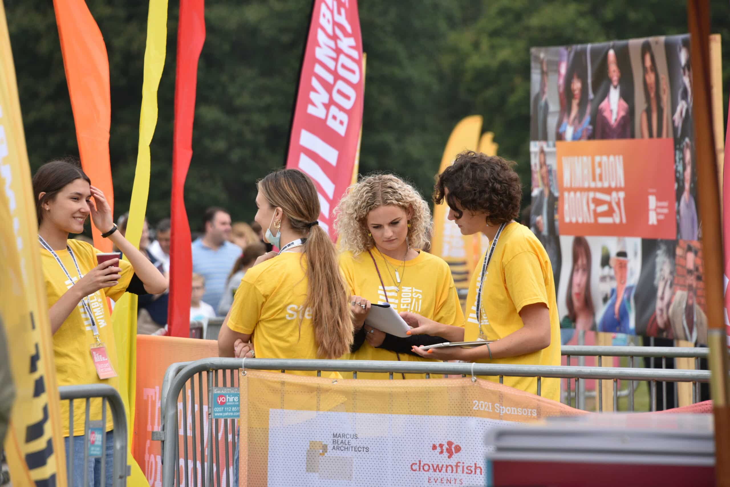 A group of staff members behind barriers at the Wimbledon Book Fest