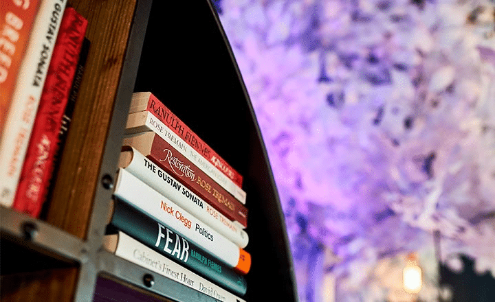 A Bookshelf with a stack of books on it, with a purple background