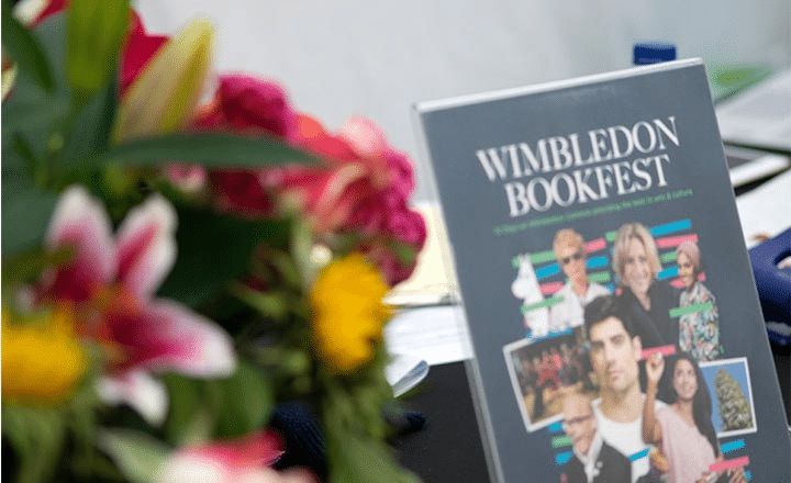 Poster for Wimbledon Bookfest on a table with flowers