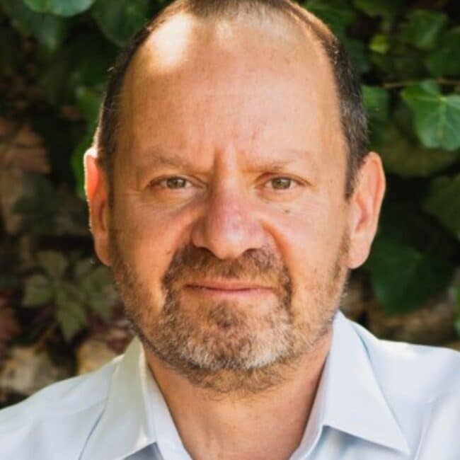 Philippe Sands, author and human rights lawyer, holding The Book of Sands at a speaking event.